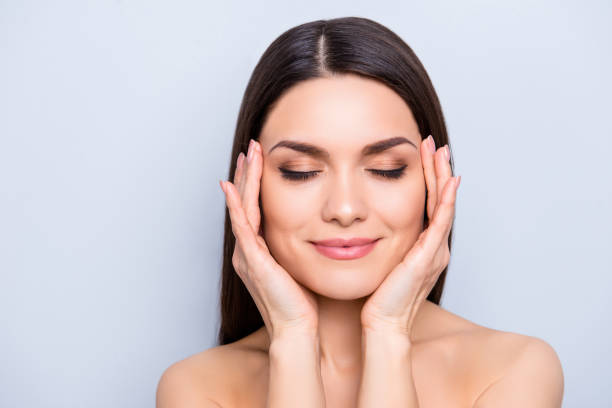 Woman practicing skincare wellness with hands gently cupping face